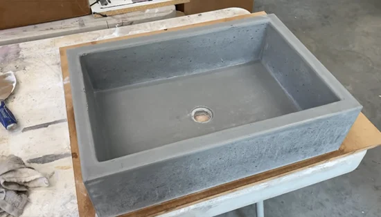 Are there any maintenance tasks that should be performed periodically after the concrete sink has been sealed
